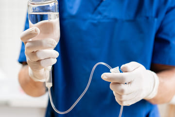 Врач держит в руках капельницу